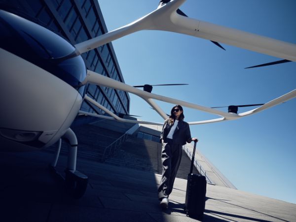 Passenger standing next to the VoloCity aircraft with their hand luggage.
